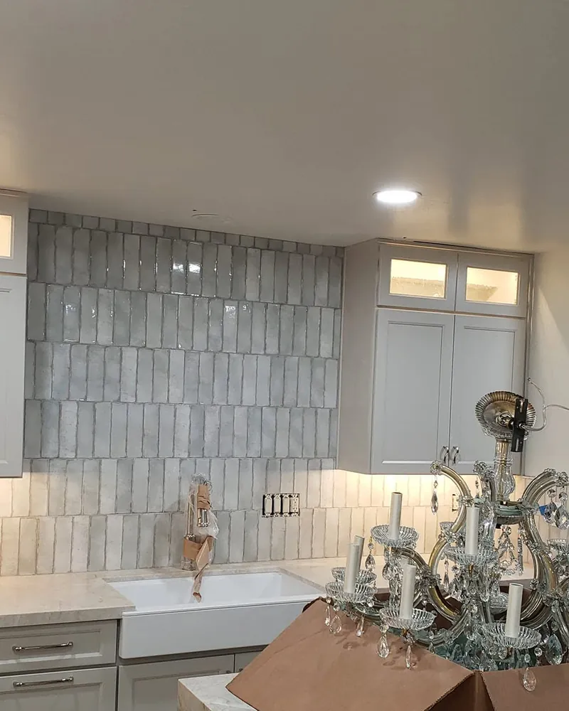 Under-cabinet lighting washing a tile backsplash in a remodeled kitchen